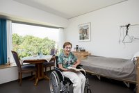 Seniorin im Rollstuhl in ihrem Zimmer