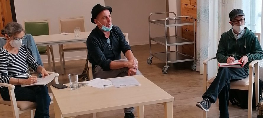 Drei Personen sitzen im Gemeinschaftsraum