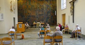 Besichtigung renovierte Stadtkirche Stuttgart-Untertürkheim Senioren sitzen im Kirchenraum auf Stühlen und lauschen