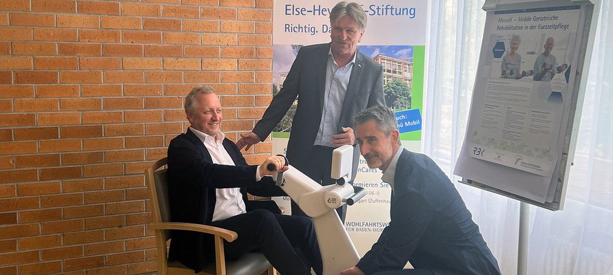 Der Gesundheitsminister und Projektpartner testen ein Trainingsgerät.